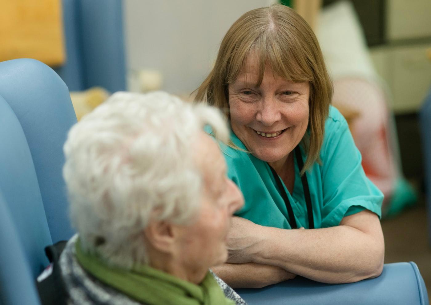 A support worker in a friendly conversation with an older woman