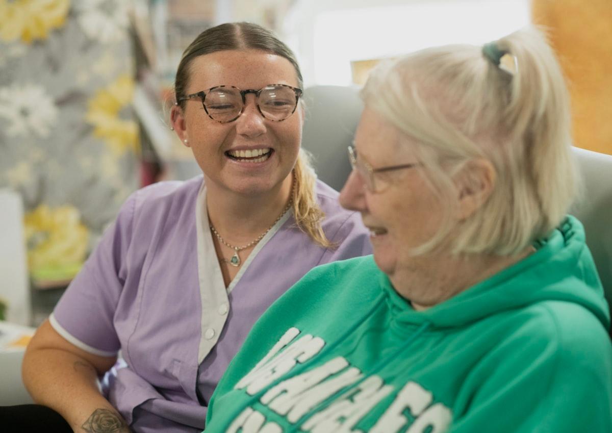 A support worker sharing a laugh with a participant at home