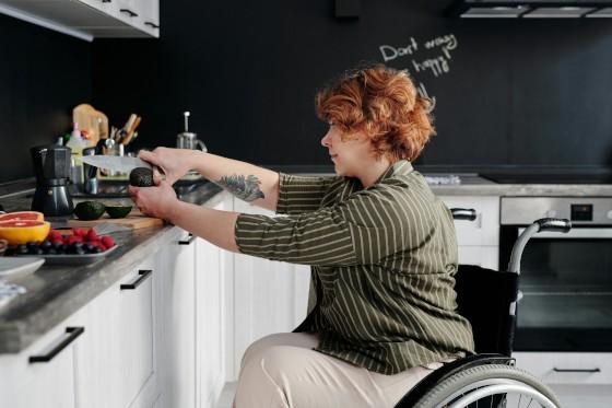 A woman practising food preparation skills, cutting avocados in a kitchen