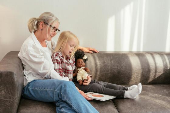 A support worker reading a picture book with a child
